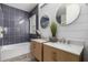 Bathroom with dual vanities, modern fixtures, and a combination tub and shower with blue tile surround at 1827 S 237Th Dr, Buckeye, AZ 85326