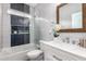 Modern bathroom featuring stylish tile work, vanity with framed mirror, and bathtub with glass partition at 1827 S 237Th Dr, Buckeye, AZ 85326