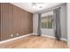 Cozy bedroom with wood accent wall, ceiling fan, and large window, offering a warm and inviting space at 1827 S 237Th Dr, Buckeye, AZ 85326