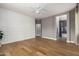 Bedroom featuring hardwood floors, a paneled accent wall, and an open doorway to an en-suite bathroom at 1827 S 237Th Dr, Buckeye, AZ 85326