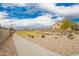 A well-manicured community park features open green spaces and a playground under a bright, cloudy sky at 1827 S 237Th Dr, Buckeye, AZ 85326