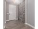 Entryway with hard wood floors, a stone accent wall, and neutral paint at 1827 S 237Th Dr, Buckeye, AZ 85326