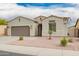 Close up of single-story home with neutral paint, well-manicured front yard and two car garage at 1827 S 237Th Dr, Buckeye, AZ 85326