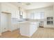 Bright kitchen featuring stainless steel appliances, an island, and white cabinetry, with plank flooring at 1910 E Empeltre Rd, San Tan Valley, AZ 85140