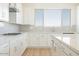 Close-up view of a bright kitchen featuring stainless steel appliances, an island, and white cabinetry at 1910 E Empeltre Rd, San Tan Valley, AZ 85140