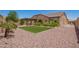 Spacious backyard featuring a covered patio, artificial turf, desert landscaping, and privacy wall at 19740 W Sherman St, Buckeye, AZ 85326