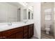 Bright bathroom featuring double sinks, wood cabinets, and a separate toilet room at 19740 W Sherman St, Buckeye, AZ 85326