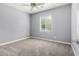 Well-lit bedroom with plush carpeting, a ceiling fan, and a large window offering plenty of natural light at 19740 W Sherman St, Buckeye, AZ 85326