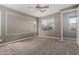 Cozy bedroom with a ceiling fan, neutral carpet, and two windows that bring in natural light at 19740 W Sherman St, Buckeye, AZ 85326