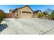 Spacious driveway leading to a two-car garage, complemented by desert landscaping at 19740 W Sherman St, Buckeye, AZ 85326