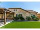 Charming home exterior featuring artificial turf, desert landscaping, and a cozy patio with a pergola at 19740 W Sherman St, Buckeye, AZ 85326