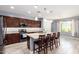 Open-concept kitchen with a center island, granite countertops, and wood-look tile flooring at 19740 W Sherman St, Buckeye, AZ 85326