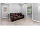 Cozy living room featuring plush carpeting and a comfortable leather sofa, perfect for relaxation at 19740 W Sherman St, Buckeye, AZ 85326