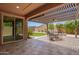 Inviting covered patio with stone flooring, an outdoor dining set, and access to a backyard at 19740 W Sherman St, Buckeye, AZ 85326