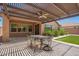 Charming outdoor patio with stone flooring, dining set, pergola and a ceiling fan at 19740 W Sherman St, Buckeye, AZ 85326