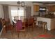 Open dining area with a large wood table, chairs, and barstool seating at the kitchen counter at 22016 W Loma Linda Blvd, Buckeye, AZ 85326