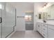 Modern bathroom with glass shower, vanity with double sinks and tile floors at 24116 N 172Nd Ave, Surprise, AZ 85387