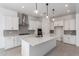 Open kitchen with large island, stainless appliances, and sleek white cabinetry at 24116 N 172Nd Ave, Surprise, AZ 85387