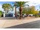 Charming front yard with a modern garage, desert landscaping, and mature palm trees at 2632 E Mountain View Rd, Phoenix, AZ 85028