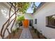 Inviting front entrance with decorative tiling, a vibrant orange front door, and mature landscaping at 2632 E Mountain View Rd, Phoenix, AZ 85028