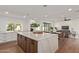 Open kitchen featuring a large island with waterfall countertops, seating, and seamless flow into the living area at 2632 E Mountain View Rd, Phoenix, AZ 85028