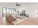 Airy living room with light hardwood flooring, modern ceiling fan, and large windows for ample natural light at 2632 E Mountain View Rd, Phoenix, AZ 85028