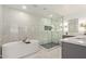 Sleek main bathroom with a soaking tub, glass-enclosed shower, and modern gray vanity at 2632 E Mountain View Rd, Phoenix, AZ 85028