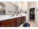 Bathroom featuring a double sink vanity, a large mirror, and walk-in closet for plenty of storage at 27878 N 175Th Dr, Surprise, AZ 85387