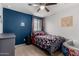 Colorful bedroom features a bed with geometric bedding, gray walls and carpeted floors at 27878 N 175Th Dr, Surprise, AZ 85387