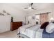 Serene bedroom with a large window, ceiling fan, natural light, and en suite bathroom at 27878 N 175Th Dr, Surprise, AZ 85387