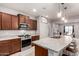 Well-equipped kitchen with dark wood cabinets, a large island, stainless steel appliances, and a view to the dining area at 27878 N 175Th Dr, Surprise, AZ 85387