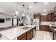 Modern kitchen with granite countertops, stainless steel appliances, and a view of the living area at 27878 N 175Th Dr, Surprise, AZ 85387