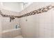 Walk-in shower featuring neutral-colored tiles, a built-in bench, and tiled shampoo niche at 27878 N 175Th Dr, Surprise, AZ 85387