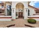 Arched entrance with a brick walkway leading to a wooden front door and decorative landscaping at 3522 E Fountain St, Mesa, AZ 85213