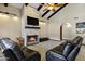 Cozy living room features a stone fireplace, beamed ceiling, and comfortable black leather seating at 3522 E Fountain St, Mesa, AZ 85213