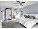 Spacious main bedroom with white bedding, ceiling fan and doorway to the ensuite bathroom at 3522 E Fountain St, Mesa, AZ 85213