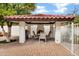 Outdoor grilling and dining area with a pitched tile roof and outdoor fireplace at 3522 E Fountain St, Mesa, AZ 85213