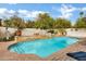 Sparkling swimming pool surrounded by brick coping, a retaining wall, lush greenery, and fruit trees at 3522 E Fountain St, Mesa, AZ 85213