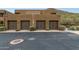 Exterior view of garages with desert landscaping, stone accents, and ample parking space at 36600 N Cave Creek Rd # C17, Cave Creek, AZ 85331