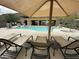 Relax on pool loungers under a large umbrella with views of the community pool at 36600 N Cave Creek Rd # C17, Cave Creek, AZ 85331