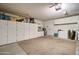 Tidy garage with built-in white storage cabinets and a door leading to the home's interior at 372 W Larona Ln, Tempe, AZ 85284