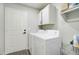 Well-lit laundry room featuring a white washer and dryer with upper cabinets and a convenient folding area at 372 W Larona Ln, Tempe, AZ 85284