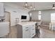 Open concept living room with kitchen island, modern lighting, wood floors, and comfortable seating at 372 W Larona Ln, Tempe, AZ 85284