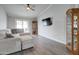 Bright living room with wood floors, modern furniture, TV, and glass cabinet at 372 W Larona Ln, Tempe, AZ 85284