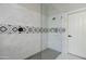 Tiled shower with shower head, glass doors, built-in niche, and tile flooring at 372 W Larona Ln, Tempe, AZ 85284