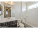 Well-lit bathroom features a shower-tub combo, white tile surround, and a vanity with dark wood cabinetry at 3901 S Adobe Dr, Chandler, AZ 85286