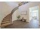 Grand foyer with a curved staircase, tile flooring, and a stylish bench adding to the home's welcoming ambiance at 3901 S Adobe Dr, Chandler, AZ 85286