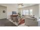 Bright living room with a large sectional sofa and modern decor, illuminated by natural light and a ceiling fan at 3901 S Adobe Dr, Chandler, AZ 85286