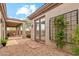 Backyard with a covered patio, landscaped gravel area, and blooming plants near the light-colored home exterior at 40614 N Harbour Town Ct, Anthem, AZ 85086