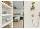 Spa-like bathroom featuring shelving, tiled shower with greenery, and a glimpse into the bedroom at 40614 N Harbour Town Ct, Anthem, AZ 85086